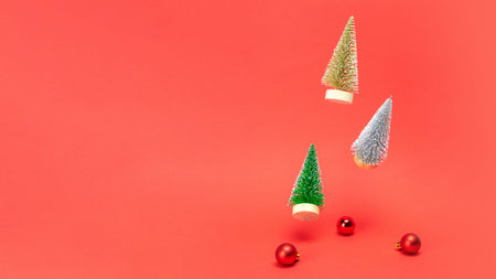 Christmas sale. Silver, golden and green winter tree fall with red balls and sparkling lights in xmas composition on dark red background for greeting card. Decoration and copy space for your text.の写真素材