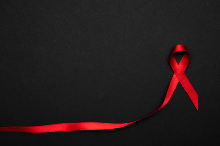 Infection symbol. Red ribbon symbol in hiv world day on dark background. Awareness aids and cancer. Healthcare and medical conceptの写真素材