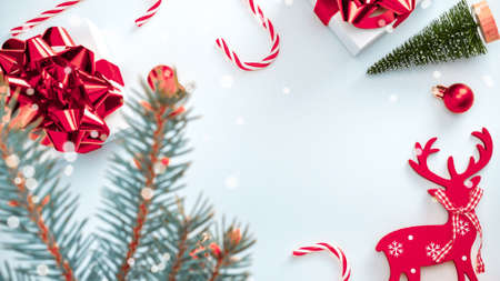 Noel design. White gift box with red ribbon, New Year balls and winter tree in Christmas composition on white background for greeting card. Xmas backdrop with space for textの写真素材