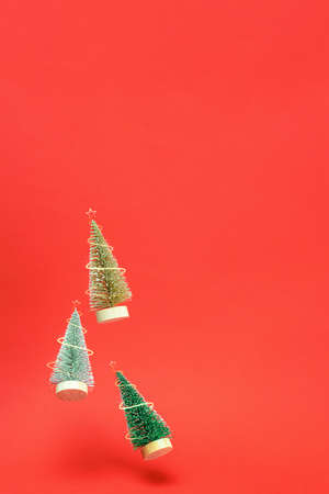 Christmas background. Silver, golden and green winter tree fall with sparkling lights in xmas composition on dark red background for greeting card. Copy space. Winter holidaysの写真素材