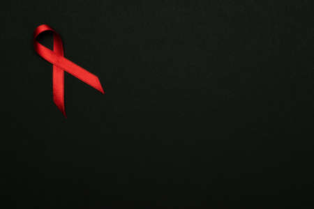 Hiv day. Red ribbon symbol in hiv world day on black background. Awareness aids and cancer. Aging health month conceptの写真素材