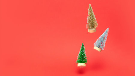 Christmas background scarlet. Silver, golden and green winter tree falling in xmas decoration on reddish background. Winter festive composition with copy spaceの写真素材