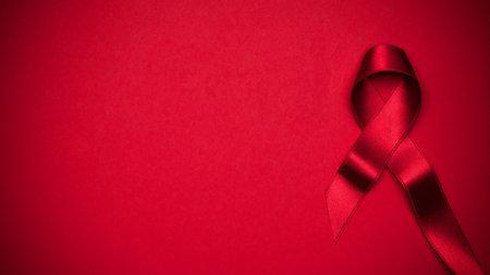 Hiv support. Red ribbon symbol in hiv world day on dark red background. Awareness aids and cancer....
