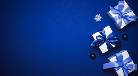 Happy Christmas. White gift with cyan bow, blue balls and winter tree in xmas decoration on azure background for greeting card. Christmas, winter, new year conceptの写真素材
