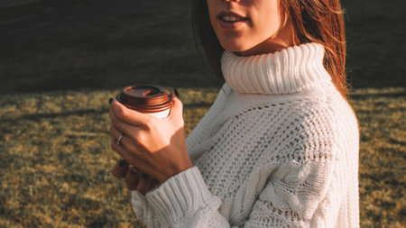 Girl drink coffee. Happy young woman with cup of tea in morning sitting outdoors sunlight. Beautiful female lifestyleの写真素材