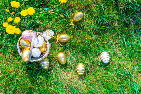 Easter egg background. Golden egg with yellow spring flowers in celebration basket on green grass....