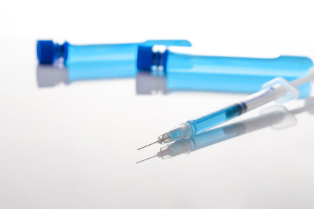 Medical needle bottles. Medical syringe with needle for protection flu virus and coronavirus. Covid vaccine isolated on white. Health care in hospitalの写真素材