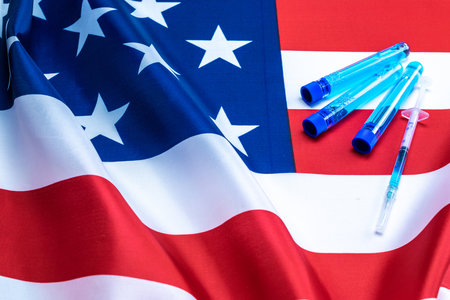 Injection usa. Medical syringe with needle for protection flu virus and coronavirus. Covid vaccine on american flag background. Concept fight against virus covid-19の写真素材