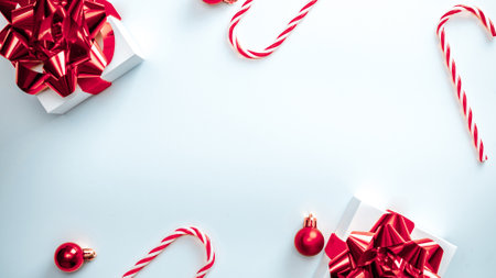 2021 White gift box with red ribbon, New Year balls, candy and sparkling lights in Christmas composition on white background for greeting card. Decoration and copy space for your textの写真素材