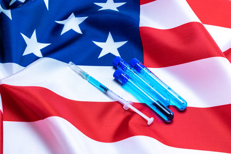 Vaccine usa isolated. Medical syringe with needle for protection flu virus and coronavirus. Covid immunization on american flag background. Concept fight against virus covid-19の写真素材