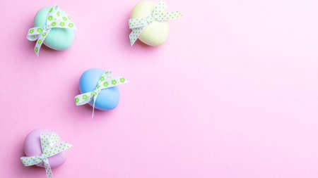Easter message. Colorful egg with tape ribbon on pastel pink background in Happy Easter decoration. Foil minimalist egg design, modern top view templateの写真素材