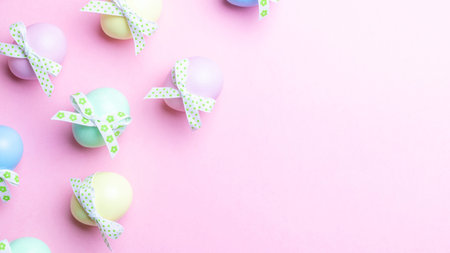 Easter pattern. Colorful egg with tape ribbon on pastel pink background in Happy Easter decoration....