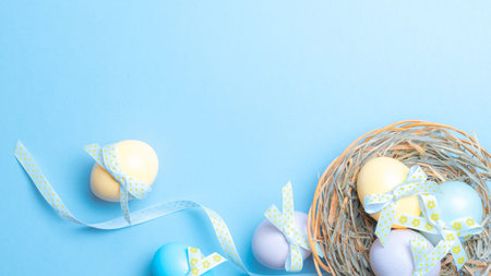 Easter frame. Colorful egg with tape ribbon on pastel blue background in Happy Easter decoration....