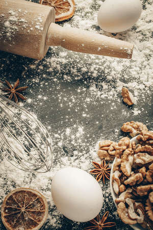 Bakery food. Fresh food ingredients: flour, eggs, nut and star anise, orange on black chalkboard background for bread. Cooking flat lay with copy space. Top view. Baking conceptの写真素材