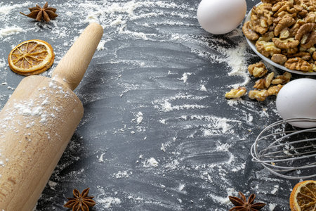 Bakery products. Cooking food ingredients: flour, eggs, nut and star anise, orange on dark table...