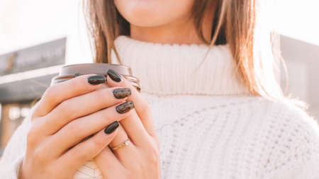 Tea drinking woman. Happy young girl with cup of coffee in sun sitting outdoor. Cup of Hot Beverageの写真素材
