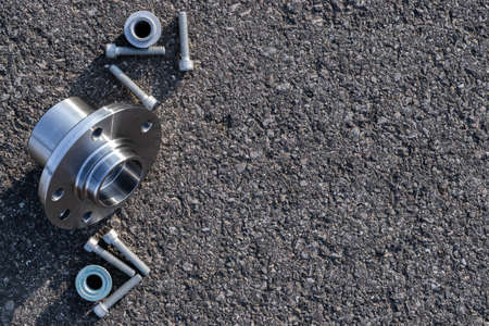 Car motor parts. Auto motor mechanic spare or automotive piece on dark road asphalt background. Set of new metal car part. Black bituminous textured waterproofingの写真素材
