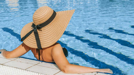 Young women pool. Happy young sexy girl in bikini swimsuit, sunglasses and straw hat in blue water. Travel holidays vacation. Beauty, wellness, lifestyleの写真素材