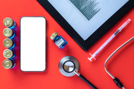 Cellphone mockup. Syringe with needle, hospital healthcare charts, doctor stethoscope and black smartphone with blank screen for medical equipment background with clipping path, copy spaceの写真素材