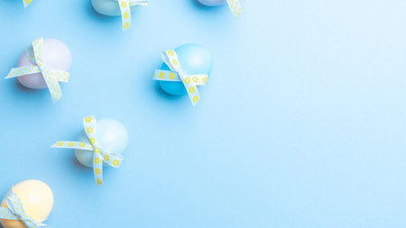 Easter banner. Colorful egg with tape ribbon on pastel blue background in Happy Easter decoration....