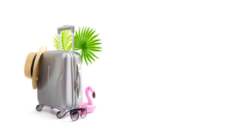 Summer pattern background. Suitcase, sunglasses with palm leaves, pink flamingo and straw hat in travel composition isolated on white background. Design of summer vacation holiday with copy spaceの写真素材