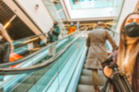 Bokeh Shopping mall background. Interior of retail center store in soft focus. People shopping in modern commercial mall center. Fashion market hallの写真素材
