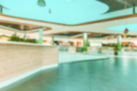 Shopping mall interior blurred background. People shopping in modern commercial mall center....