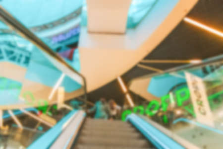 Shopping center people blurred background. People shopping in modern commercial mall center. Interior of retail center store in soft focus. Luxury inside business hallの写真素材