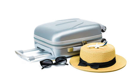 Travel suitcase isolated. Travel accessories with suitcase, straw hat, toy airplane in minimal trip vacation concept isolated on white background. Design of summer vacation holiday conceptの写真素材