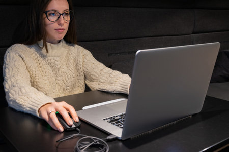 Using internet. Beautiful young freelancer business woman using laptop computer and sitting at cafe...