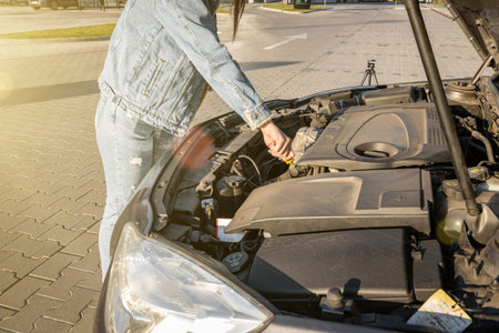 Broken down car. Vehicle engine motor problem concept. Driver girl near open hood auto
