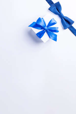 Gift father day. Blue bowtie or tie, white box with bow ribbon on light background. Happy loving family and Fathers Day concept.の写真素材