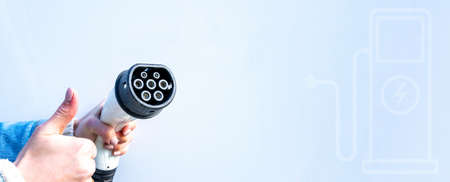 Electric car charging station. Power cable pump plug in recharge fuel technology with cable to power battery. Eco green energy hybrid vehicle on future charger station. EV fuel Plug in hybrid carの写真素材