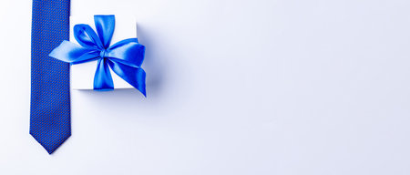 Gift dad. Blue bowtie or tie, white box with bow ribbon on light background. Happy loving family and Fathers Day conceptの写真素材