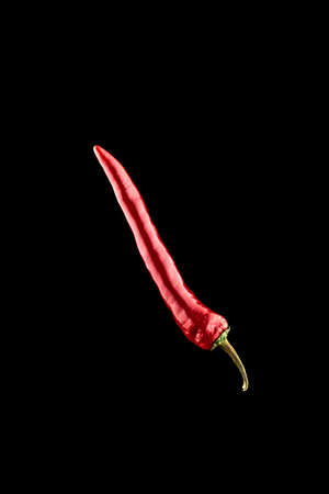 Cayenne chilli. Red hot chili paprika or spicy chile cayenne pepper isolated on black background. Fresh spice vegetable conceptの写真素材