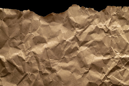 Torn craft. Kraft paper texture background. Old craft vintage cardboard isolated on black. For designs, decoration and nature background conceptの写真素材