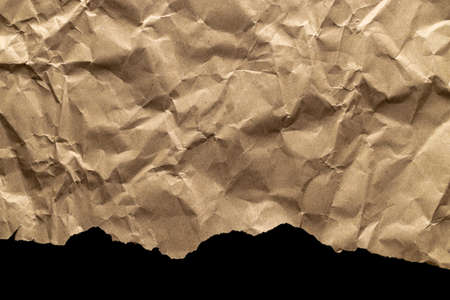 Torn craft. Kraft paper texture background. Old craft vintage cardboard isolated on black. For designs, decoration and nature background conceptの写真素材