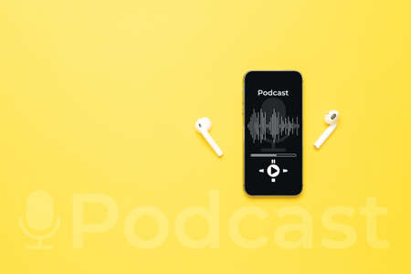 Podcast audio equipment. Audio microphone, sound headphones, podcast application on mobile smartphone screen. Recording sound voice on yellow background. Live online radio player mockup bannerの写真素材