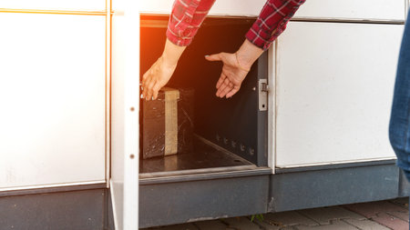 Post locker. Delivery automat terminal and hands with parcel courier box. Parcel delivery, pickup...