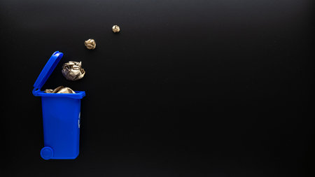 Recycle paper garbage. Blue dustbin for recycle paper trash on black background. Bin container for...