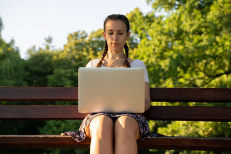 Girl computer tablet work outside. Student woman outdoor with business online technology in summer nature park. Person people with laptop. Happy hipster young distance learning conceptの写真素材