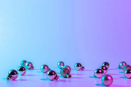 Christmas balls neon winter background. Xmas bauble on abstract holiday gradient backdrop. Happy new year copy spaceの写真素材