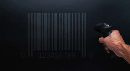 Barcode concept. Retail label barcode scan. Reader laser scanner for warehouse on black background. Warehouse inventory management.の写真素材