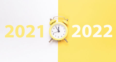 Christmas flat lay 2022. Retro style yellow clock in happy xmas midnight. Countdown to new year on...
