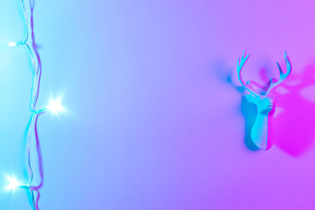 Deer lights neon Christmas winter background. Minimal abstract xmas reindeer. Holiday decoration bauble ball on neon gradient backdrop. Minimal new year cardの写真素材