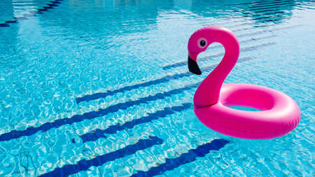 Beach flamingo. Pink inflatable flamingo in water for summer beach background. Pool float partyの写真素材