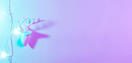 Deer lights neon Christmas winter background. Minimal abstract xmas reindeer. Holiday decoration bauble ball on neon gradient backdrop. Minimal new year cardの写真素材