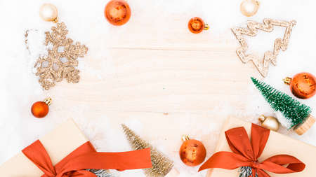 Snow wood background. Christmas board with old rustic wall, white frozen snowflake, golden balls and gift box. Winter wooden decoration background. Merry Christmas holiday card patternの写真素材