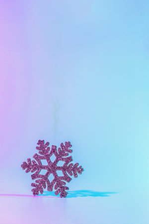 Neon Christmas winter background. Minimal abstract xmas snowflake. Holiday decoration snow on night pink gradient. Happy new year copy spaceの写真素材