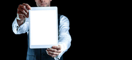 Screen mockup. Empty blank tablet in businessman hand. Mock up screen smart device isolated on black banner background. Game design, mobile application presentation or portfolio mockupsの写真素材
